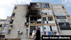 Čovjek sa psom nakon raketnog napada u Gazi, 11. oktobar 2023. 