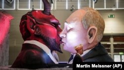 A carnival float depicts Russian President Vladimir Putin kissing the devil at a parade in Cologne, Germany, on February 14.