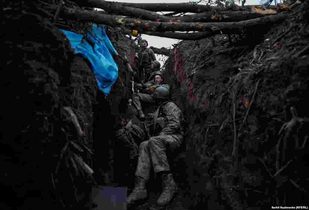 După un schimb de focuri cu forțele rusești, soldații obosiți pot să se relaxeze pentru câteva momente.