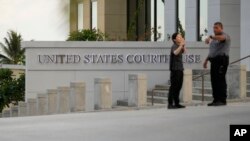 Osiguranje ispred zgrade suda na Saipanu, Marijanska ostrva, 26. juna 2024.