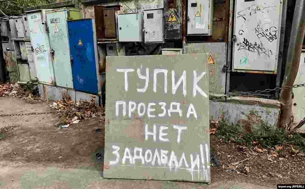 Электрощитки на бетонном заборе на противоположном берегу реки