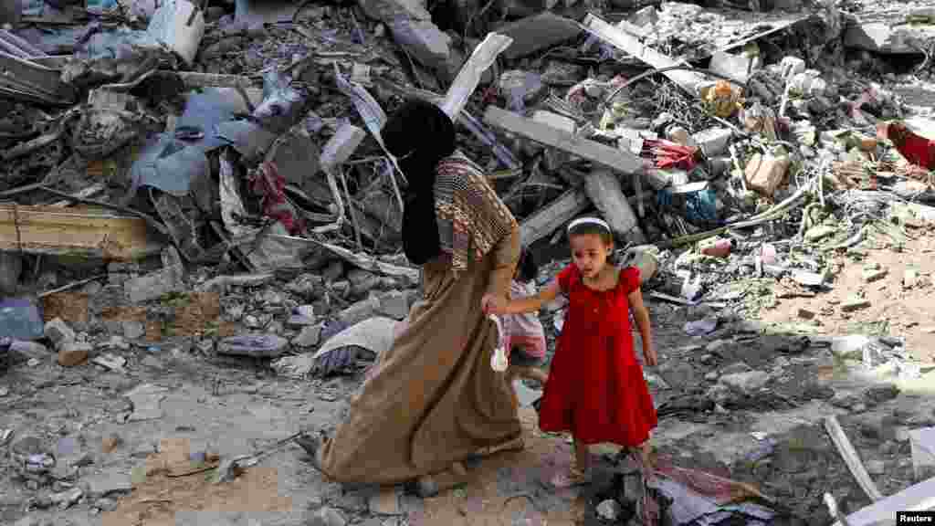 Egy palesztin nő és gyermeke az izraeli csapások után azon a területen, ahol előző nap, június 8-án, szombaton négy izraeli túszt mentett ki élve az izraeli hadsereg. A Gázai övezet középső részén lévő&nbsp;Nuszejrat menekülttáborban végrehajtott izraeli rajtaütésben&nbsp;kétszázhetvennégy palesztin halt meg, miután a túszokat&nbsp;szállító izraeli mentőautó elakadt a táborban, és&nbsp;palesztin fegyveresek tüzet nyitottak az autóra,&nbsp;miközben Izrael szárazföldi és légi csapásokat mért a területre, hogy fedezze a partra evakuálást