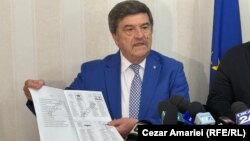 Toni Greblă, președintele Autorității Electorale Permanente din România, arată un model de buletin de vot care va fi folosit la alegerile din 9 iunie