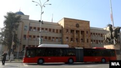 Një autobus ndërurban duke kaluar pranë ndërtesës së Kuvendit maqedonas, Shkup.