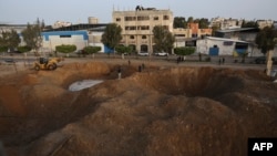 Palestinci hodaju na području u Gazi uništenom u izraelskim zračnim napadima na palestinsku enklavu, 7. travnja 2023.