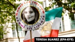 Demonstrant nosi portret Mahse Amini, koja je umrla u pritvoru nakon što ju je uhapsila iranska moralna policija u septembru 2022., tokom demonstracija u blizini iranske ambasade u Parizu, Francuska, 23. maja 2023.