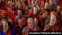 Pristalice indijskog premijera Narendre Modija nose maske s njegovim licem dok prisustvuju predizbornom skupu u Meerutu, Indija, 31. marta 2024.