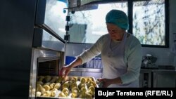 Një kuzhiniere duke përgatitur kifle për kopshtet në Prishtinë.