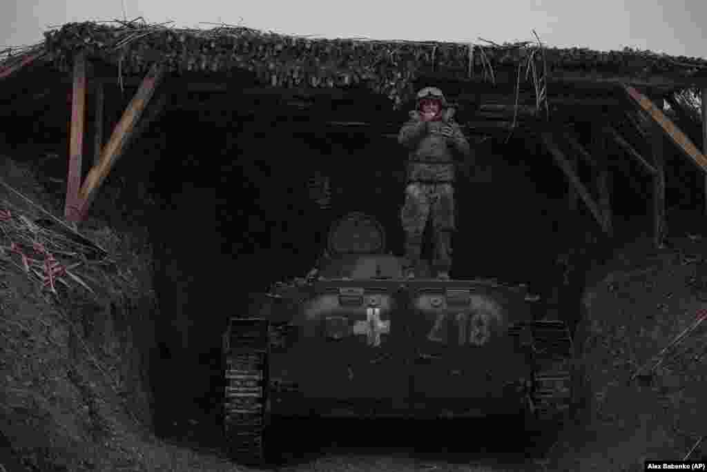Ukrajinski vojnik puši cigaretu dok stoji na vrhu oklopnog vozila blizu linije fronta u blizini Bahmuta. &nbsp;