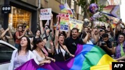 Членови и поддржувачи на ЛГБТК заедницата држат знамe во боите на виножито и извикуваат слогани за време на неовластениот Марш на гордоста во Истанбул, на 25 јуни 2023 година.