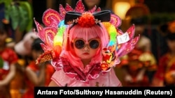 Момиченце носи традиционна китайска рокля чонгсам по време на модно ревю в търговски център в Южен Тангеранг, провинция Бантен, Индонезия, 8 февруари 2024 г. Китайската Нова година започва на 10 февруари 2024 г. под знака на Дървения дракон.