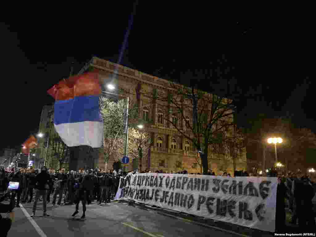 Grupa maskiranih muškaraca, među kojima i oni sa obeležjima ruske paravojne formacije Vagner razvila je transparent &quot;Narod i crkva u odbrani zemlje, protiv izdaje je jedino rešenje&quot;.