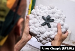 Kolodko with his work-in-progress of Putin. The artist makes his statuettes from plasticine, from which a cast is made and molten bronze is eventually poured into.