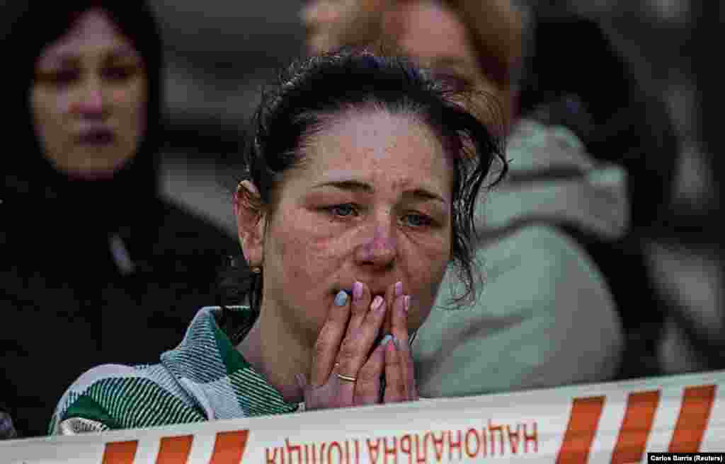 A woman reacts at the site of a heavily damaged residential building in Uman.