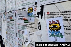 ჩამოხეულ პროსახელისუფლებო ბანერებს თავიანთი სტიკერები გადააკრეს კანონის მოწინააღმდეგეებმა.