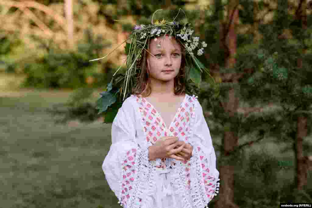 Djevojčica koja nosi cvjetni vijenac&nbsp;promatra svečanost.