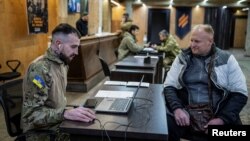 Dobrovoljac koji želi da se pridruži 3. zasebnoj jurišnoj brigadi Oružanih snaga Ukrajine razgovara sa oficirima za regrutaciju, usred ruskog napada na Ukrajinu, na nepoznatoj lokaciji u regiji Kijev, Ukrajina, 9. januara 2024.