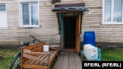 Вера Максакова живее в многофамилна жилищна сграда, пред входа на която стоят бидони с вода - предназначени за къпане, тъй като единствените удобства в апартаментите са тоалетните.