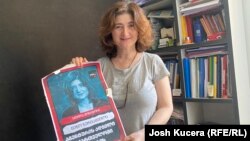 Novinarka Nino Zuriašvili sa plakatom na kojoj je njena fotografija i natpis "U Gruziji nema mjesta za agente"