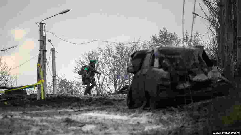 Украински войник търси прикритие от руски обстрел в Бахмут. Руските сили започнаха опитите си да превземат града през юли 2022 г. &nbsp;