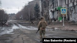 Un militar ucrainean patrulează pe o stradă goală în orașul Bahmut, Ucraina. Fotografie făcută pe 21 februarie 2023. REUTERS/Alex Babenko