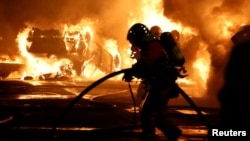 Пожарникари гасят горящи автомобили по време на сблъсъци между протестиращи и полиция след смъртта на Нахел, 17-годишен тийнейджър, убит от френски полицай, в Нантер, предградие на Париж, Франция, 28 юни 2023 