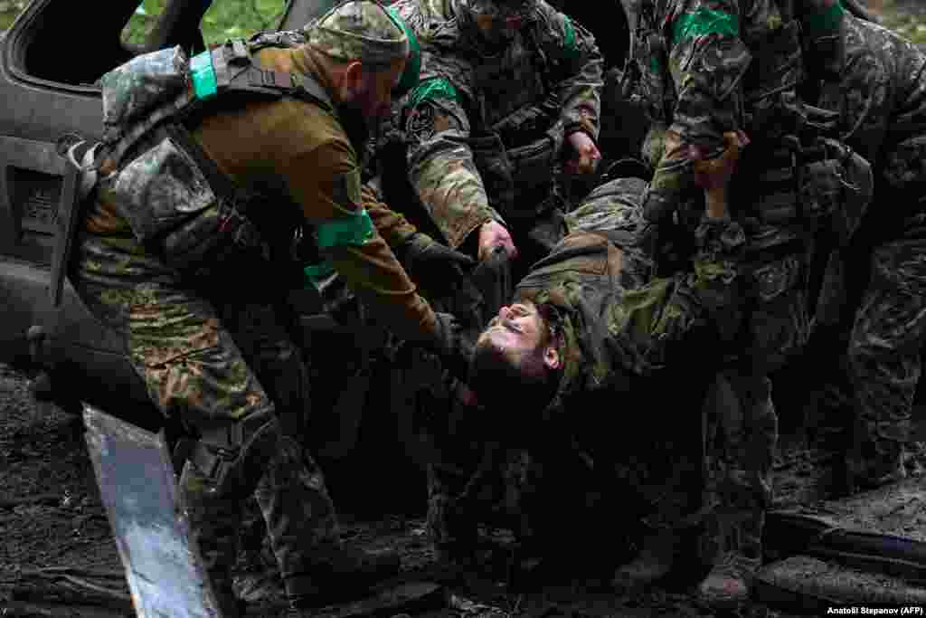 Украински войници носят ранен другар.&nbsp;Киев признава, че силите му са платили висока цена за защитата на &quot;крепостта Бахмут&quot; - град, в който преди руската инвазия живееха около 70 000 души.&nbsp;