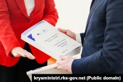 Nagavci duke ia dorëzuar raportin e rishikimit të teksteve shkollore kryeministrit të Kosovës, Albin Kurti.