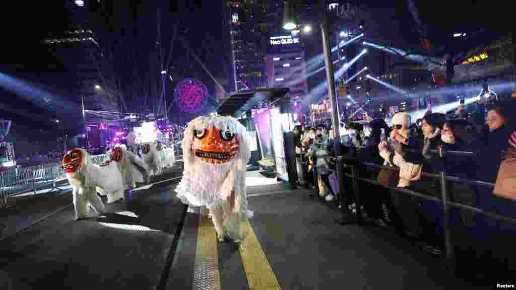 Hagyományos táncosok menetelnek az új év alkalmából rendezett ünnepségen a dél-koreai Szöulban 2023. december 31-én