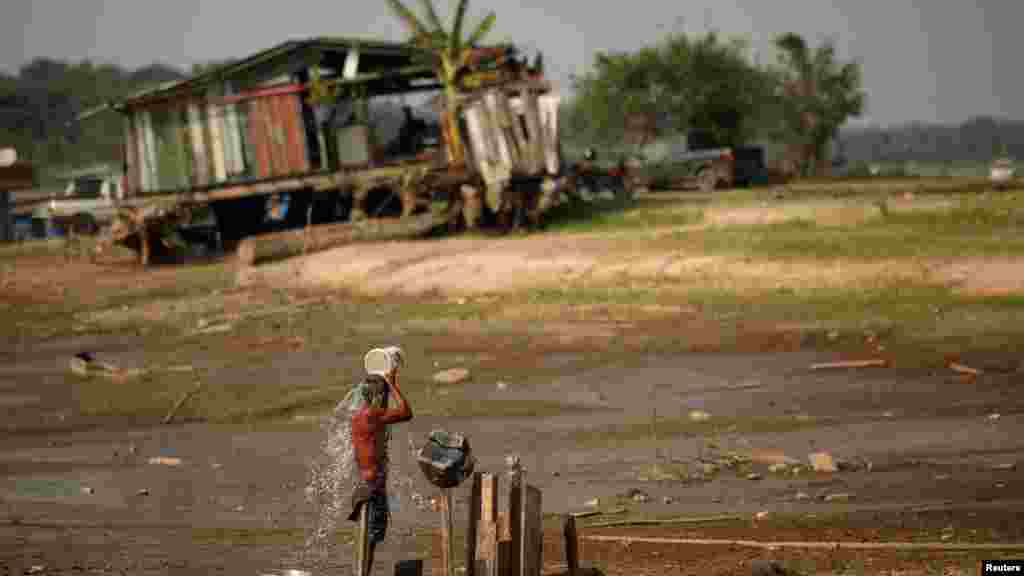 Ribar Raimundo da Silva do Carmo kupa se vodom iz bunara u jezeru Puraquequara, koje je također pogođeno sušom, Manaus, 6. oktobra 2023.