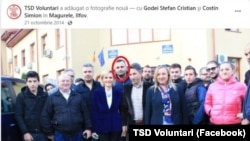 Într-o fotografie din octombrie 2014 postată de TSD Voluntari, Ştefan Godei stă chiar în spatele Gabrielei Firea. El şi Costin Simion (sacou negru, lângă actualul ministru) au fost singurele persoane menţionate cu link în postare.