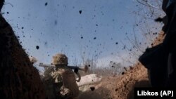 Ukraine -- A Ukrainian soldier of the 28th brigade fires a grenade launcher on the frontline during a battle with Russian troops near Bakhmut, Donetsk region, Ukraine, Friday, March 24, 2023.