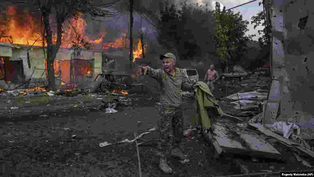 Egy ukrán katona hívja a mentősöket, miközben halottak és sebesültek hevernek körülötte a Kosztyantyinivka központjában lévő forgalmas piacot ért orosz rakétatámadást követően szeptember 6-án. Ukrán tisztviselők szerint legalább tizenhét ember, köztük egy gyermek halt meg a támadásban &nbsp;