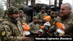 Szerhij Najev, az Ukrán Fegyveres Erők Egyesített Erőinek parancsnoka húsvéti kalácsot ad át a belarusz határra tartó katonáknak az ortodox húsvét előtt, 2023. április 15-án