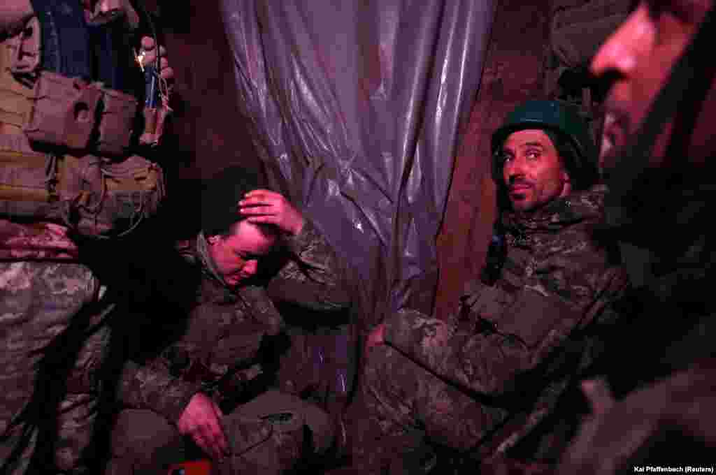 As the sounds of incoming fire rumble above, Ukrainian soldiers are forced to take cover in the dark confines of their trenches.
