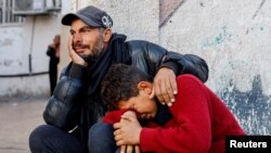 Dy palestinezë të mërzitur për personat e vrarë në një sulm izraelit në Rafah të Gazës.
