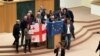 Oporbeni zastupnici u gruzijskom parlamentu slave povlačenje zakona o "stranim agentima" sa zastavama Gruzije i Europske unije, Tbilisi, 10. ožujka 2023.