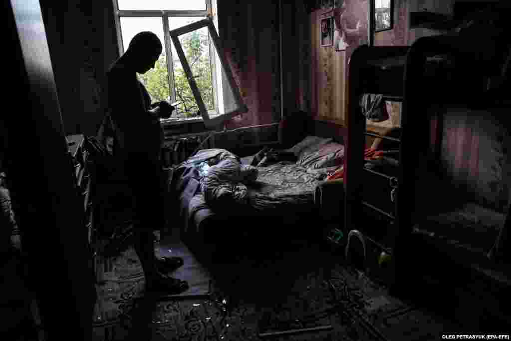 Kyiv resident Dmytro checks his phone after surveying the damage inside his flat. &quot;Damage was recorded in the Darnytskiy, Solomyanskiy, and Shevchenkivskiy districts in Kyiv as a result of falling missile pieces,&quot; said Ihor Klymenko, Ukraine&#39;s minister of internal affairs.