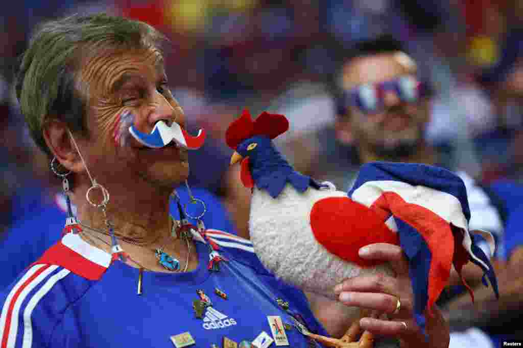 Креативен навивач на Франција на мечот со Австрија, со маскотата на триколорите