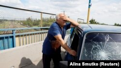 Muškarac pored oštećenog automobila na mestu ruskog raketnog udara, u Pokrovsku, Donjecka oblast Ukrajina 24. juna 2024. 