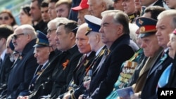 Владимир Путин (в средата) наблюдава парада в компанията на ветерани и официални гости.