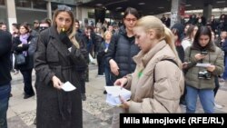 Aktivisti i studenti dele okupljenima listiće sa kontaktima Ministarstva državne uprave i lokalne samouprave kako bi ih prisutni zvali povodom otvaranja biračkih spiskova, 27.12.2023. 