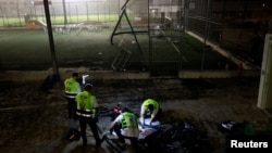 Službe za hotno reagovanje pregledaju oblast u kojoj je pala raketa u mestu Madždal Šams na Golanskoj visoravni pod okupacijom Izraela, 27. jul 2024.