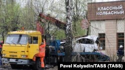 Kамион отнася отломките от кола, пострадала при взрива на 21 април 2023 г.