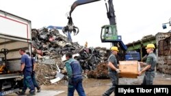 Lefoglalt és megsemmisítésre váró hamisított alkatrészeket pakolnak az adóhivatal munkatársai egy budapesti telephelyen 2017. június 7-én (képünk illusztráció)