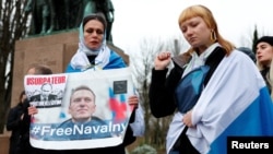 Жена държи портрет на руския опозиционен лидер Алексей Навални в Париж, Франция, на 16 февруари 2024 г. След съобщенията за смъртта му хора се събраха близо до руското посолство в града.