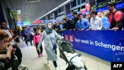 Călători pe lângă un banner pe care scrie „Bine ați venit la Schengen!” imediat după intrarea oficială a României în spațiul european de liberă circulație pe aeroportul internațional „Henri Coanda” din Otopeni, 31 martie 2024