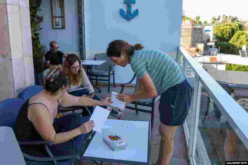 Izraeli családok, akik elmenekültek az északi Baram kibucból, egy tiberiasi szálloda erkélyén 2023. október 16-án. Az izraeli hadsereg evakuálja a Libanonnal közös, északi határ mentén élő lakosokat a Gázai övezetben