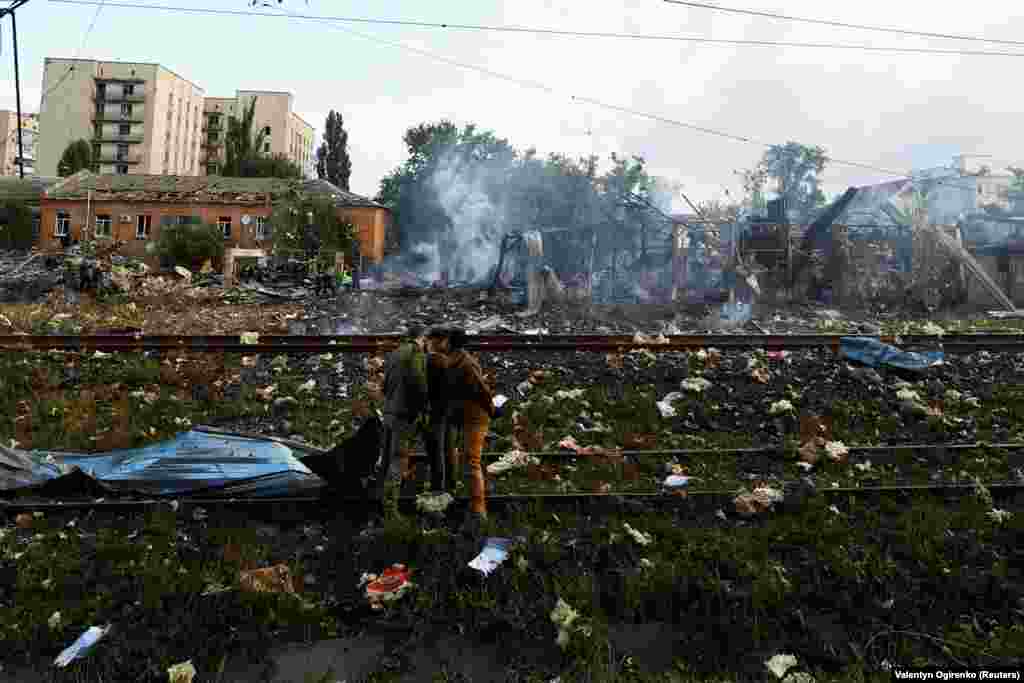 Emergency personnel examine debris at the still-smoking site in Kyiv.