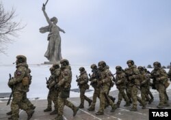 Ruski vojnici na putu za Ukrajinu marširaju pored kipa "Majka domovina zove" u Volgogradu u januaru 2023.